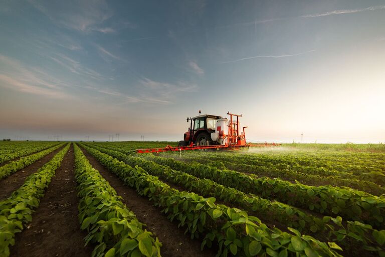 Traktor auf einem Feld, Symbol für Agrarwirtschaft