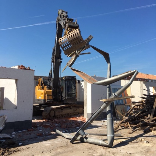 Abrissbagger mit Greifer beim Rückbau der alten Lagerhalle auf dem Betriebsgelände.